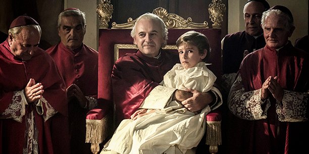 Le jeune Edgardo Mortara (Enea Sala) sur les genoux du pape Pie IX (Paolo Pierobon).