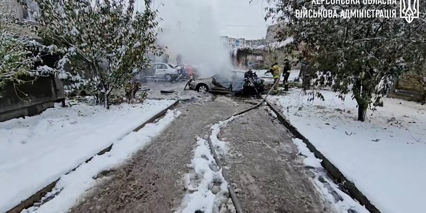 Les premiers intervenants travaillent pres de voitures incendiees apres une frappe d'artillerie russe meurtriere a kherson, en ukraine[reuters.com]