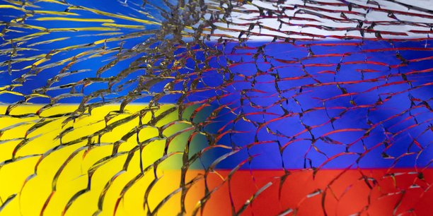 Illustration des drapeaux de l'ukraine et des drapeaux russes vus a travers du verre brise[reuters.com]