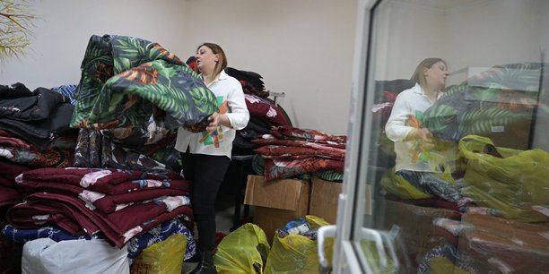 Photo de lilia abrahamian, travailleuse caritative, montre des couvertures preparees pour les refugies de la region du haut-karabakh a vanadzor[reuters.com]