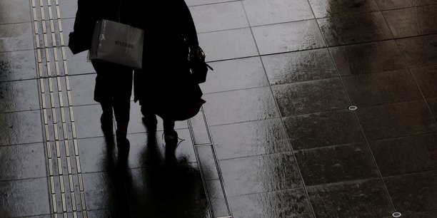 Des femmes portant un sac de courses dans un quartier commercant de tokyo[reuters.com]