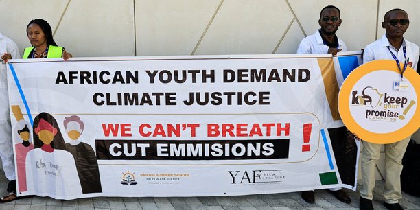 Des activistes manifestent à Dubaï (Emirats arabes unis) le 5 décembre lors de la tenue de la COP28. Sur la banderole, on peut lire : « La jeunesse africaine exige la justice climatique ».