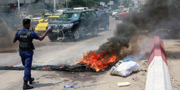 Un policier jette de l'eau sur des pneus en feu apres une manifestation pres de l'ambassade americaine a kinshasa, en rdc[reuters.com]