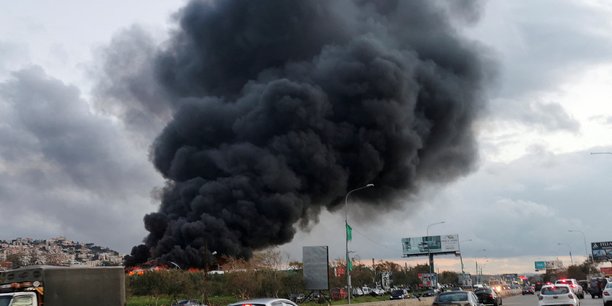 Des vehicules roulent alors que de la fumee s'eleve d'un site touche par une frappe aerienne pres de la ville de ghaziyeh, au liban[reuters.com]