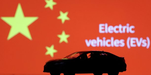 Une miniature de voiture, des mots electric vechicles (evs) et le drapeau chinois[reuters.com]