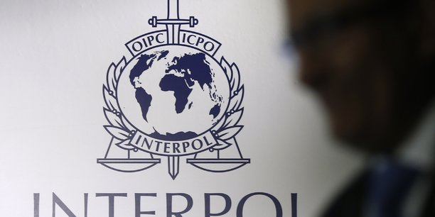 Un homme passe devant un logo d'interpol a singapour[reuters.com]