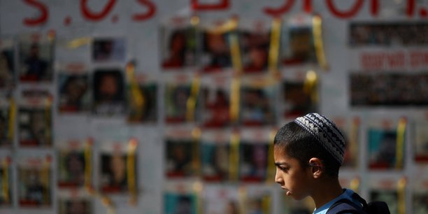 Des personnes passent devant des affiches montrant des photos d'otages enleves lors de l'attaque du 7 octobre par le hamas, a tel aviv[reuters.com]