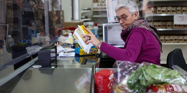 Une femme travaille a la caisse d'un supermarche[reuters.com]