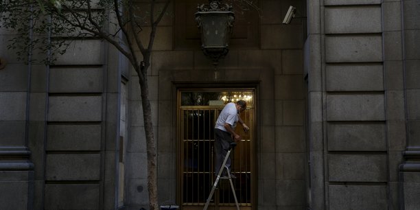 Un homme travaille en nettoyant la porte d'entree d'un batiment[reuters.com]