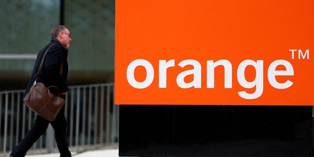 Un homme passe devant le logo de french orange pres de paris[reuters.com]