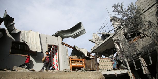 Des enfants palestiniens inspectent le site d'une frappe israelienne sur une maison a rafah[reuters.com]