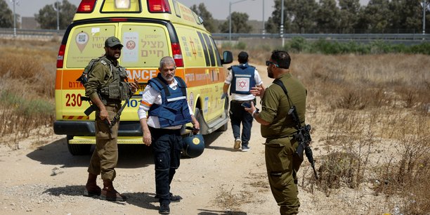 Des soldats israeliens et des medecins marchent pres d'une ambulance apres que le groupe islamiste palestinien hamas a revendique une attaque au point de passage de karem shalom, pres de la frontiere israelienne avec gaza[reuters.com]