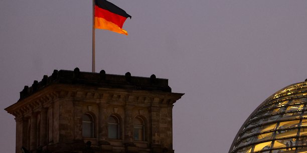 Le drapeau allemand flotte sur le batiment illumine du reichstag, le siege du bundestag[reuters.com]