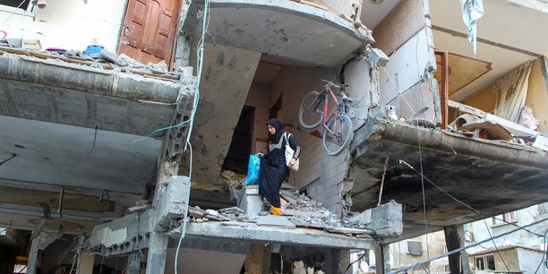 Une femme palestinienne descend les escaliers d'une maison touchee par une frappe israelienne a rafah, dans le sud de la bande de gaza[reuters.com]