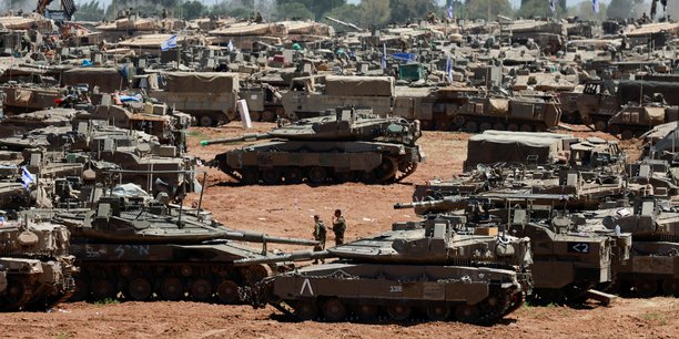 Des soldats israeliens passent devant des vehicules militaires pres de la frontiere entre israel et la bande de gaza[reuters.com]