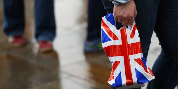 Une personne porte un sac plastique avec le drapeau britannique[reuters.com]