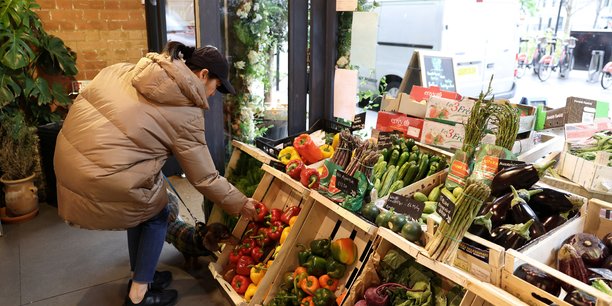 Une cliente achete des legumes a l'epicerie fine andreas, a londres[reuters.com]