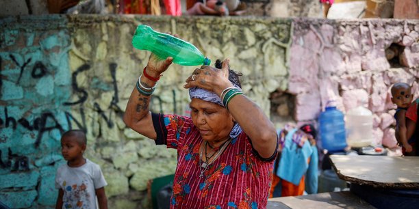 Une femme se verse de l'eau sur la tete lors d'une journee chaude a new delhi[reuters.com]