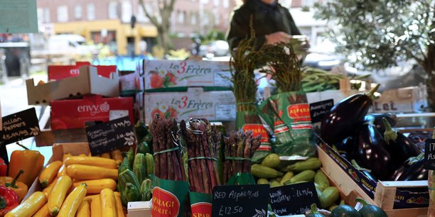 Une cliente achete des legumes a l'epicerie fine andreas a londres[reuters.com]