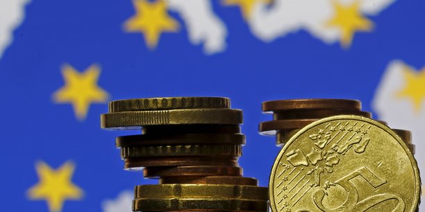 Pieces en euros devant le drapeau et la carte de l'union europeenne[reuters.com]