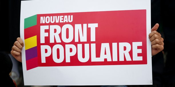 Une personne tient une pancarte avec le logo du nouveau front populaire (nfp)[reuters.com]