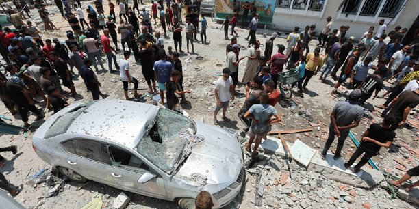 Des palestiniens inspectent une ecole abritant des personnes deplacees apres une frappe israelienne, a deir al-balah[reuters.com]