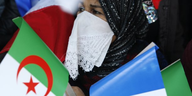 Une algerienne tenant des drapeaux algerien et francais[reuters.com]