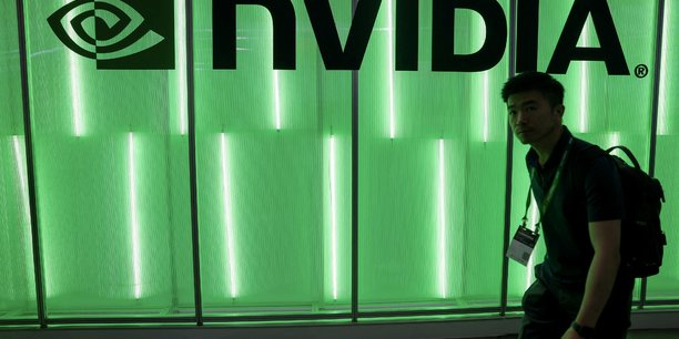 Une personne passe devant un logo nvidia[reuters.com]