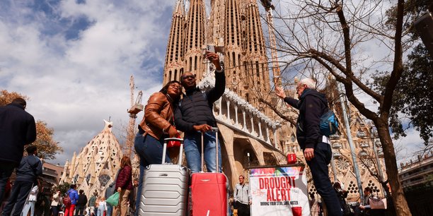 Des touristes prennent un selfie a cote de la basilique de la sagrada familia a barcelone[reuters.com]