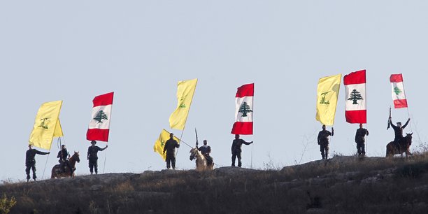 Des membres du hezbollah libanais brandissent des drapeaux du hezbollah et du liban[reuters.com]