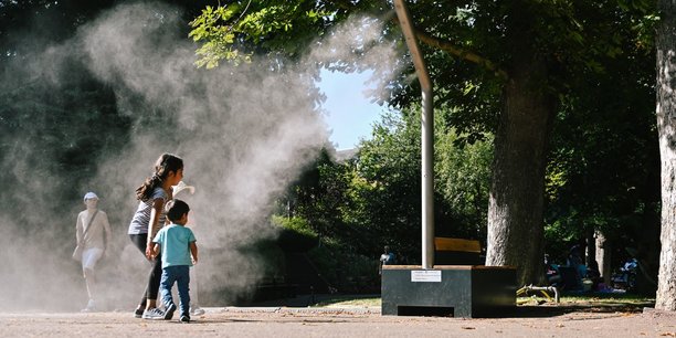 Des enfants se rafraîchissent à l'aide d'un brumisateur, au jardin Lecoq, a Clermont-Ferrand, Auvergne, le 10 août 2024.