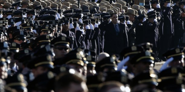 Police salute during the playing of the u.s. national anthem outside the christ tabernacle church at the start of the funeral service for slain nypd officer ramos in the queens borough of new york[reuters.com]