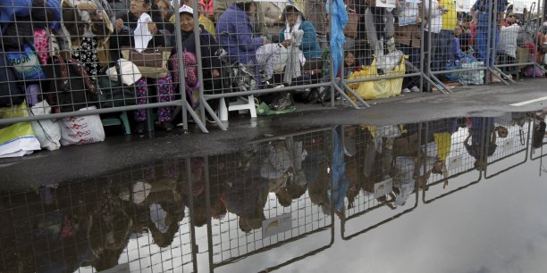 Les equatoriens bravent la pluie pour voir le pape francois[reuters.com]
