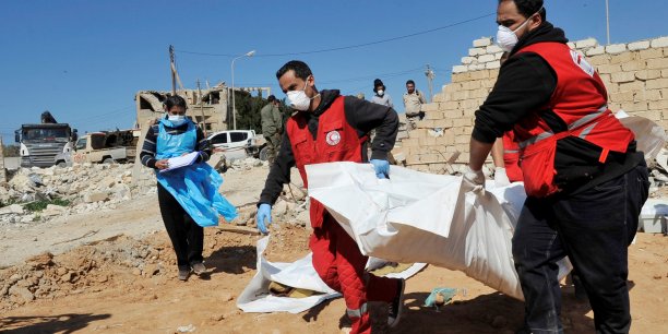 Members of the red crescent evacuate the dead bodies of unidentified people found buried in ganfouda district in benghazi[reuters.com]