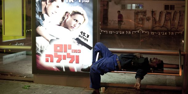 Un travailleur migrant africain endormi sur un banc d'une gare routière au sud de Tel Aviv.