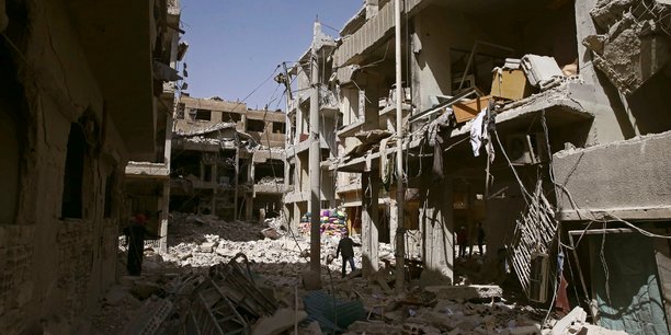 A man walks on rubble of damaged buildings in the besieged town of douma[reuters.com]
