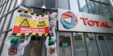 Des militants d'Attac accrochent une bannière à la façade de l'immeuble Total à La Défense, le 12 octobre 2019.