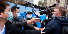 Le 31 janvier 2021, lors de la visite du marché de fruits de mer de Huanan, à Wuhan épicentre de la pandémie de covid-19, par l'équipe de l'Organisation mondiale de la santé (OMS) chargée d'enquêter sur l'origine de la maladie, le personnel de sécurité empêche les journalistes des médias étrangers de prendre des images. (Photo: Thomas Peter / Reuters)