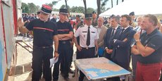 Emmanuel Macron, en déplacement à La-Teste-de-Buch, écoutant les explications du chef de corps des pompiers de Gironde, Marc Vermeulen, mercredi 20 juillet.