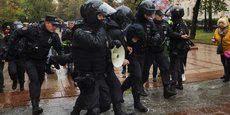 Des agents des forces de l'ordre russes détiennent une personne pendant un rassemblement à Moscou