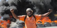 Un homme devant une barricade en feu lors d'une manifestation contre les récents meurtres de policiers par des gangs armés, à Port-au-Prince, Haïti
