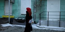 Une femme porte un sac avec de la nourriture alors qu'elle marche dans une rue à Odessa, Ukraine
