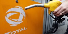 Un client tient une pompe à essence alors qu'il fait le plein de sa voiture dans une station Total à Nice