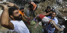 Des Palestiniens portent le corps d’un enfant mort après les frappes aériennes israéliennes sur Gaza, mardi.