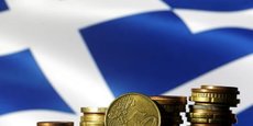 Les pièces en euros sont visibles devant un drapeau grec affiché dans cette illustration.