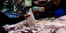 Un poissonnier tend un sac à un client dans un supermarché à Madrid