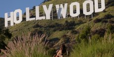 Une femme pose devant le panneau d'Hollywood, à Los Angeles