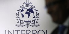 Un homme passe devant un logo d'Interpol à Singapour
