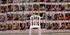 Une chaise est laissée devant des affiches avec des photos d'otages