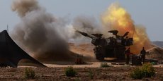 Un véhicule militaire israélien tire près de la frontière entre Israël et Gaza